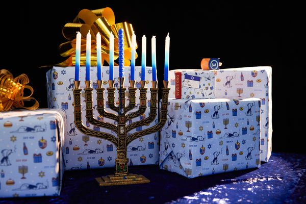 hanukkah candles and 4 gifts surrounding the menorah