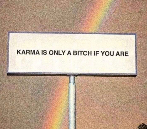 A large sign with a rainbow shining over it, reading " karma is only a bitch if you are".