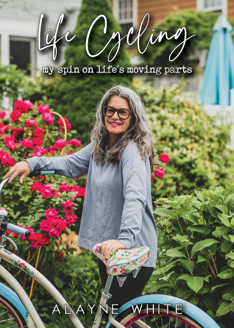 a smiling woman holding a bike on the front cover of a book 